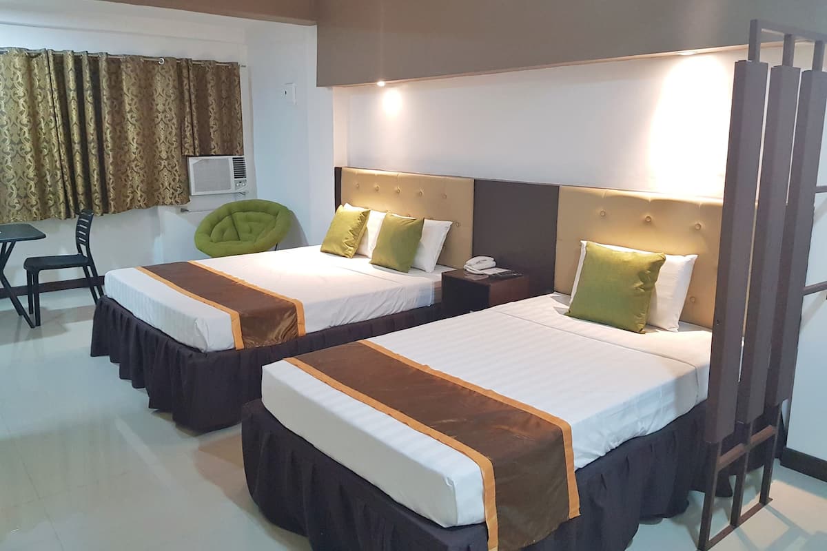Une chambre d’hôtel avec deux lits, chacun doté d’une tête de lit, de tables de chevet et d’une chaise.
