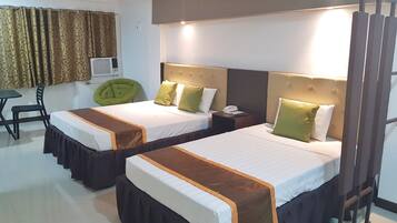 Ein Hotelzimmer mit zwei Betten, jeweils mit Kopfteil, Nachttischen und einem Sessel.