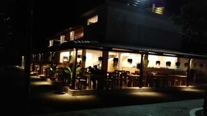 Un restaurante con terraza, iluminado por luces ambientales.