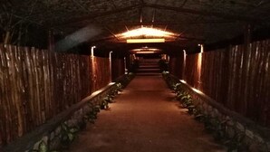 Un pasillo tenuemente iluminado con paredes de madera y una lámpara en el centro.