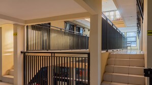 A hotel interior with a staircase, a metal gate, and a sign indicating room number 206. - Capital O 989 Audah Guesthouse Syariah (Jakarta)