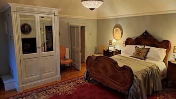 Une chambre à coucher avec un grand lit, une armoire, un lustre et une moquette rouge.