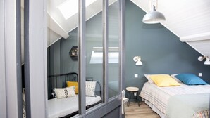 A bedroom with a bed, bedside table, and a window. - Une Odeur de Tilleul (Montbrison)