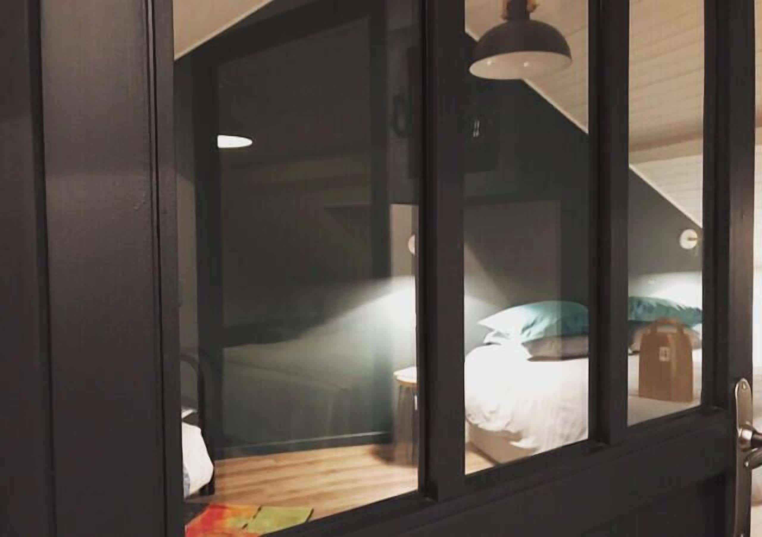 Un dormitorio con cama, mesita de noche y lámpara.