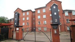A brick building with a gated entrance, labeled "Hunter's Wharf." - Select Serviced Accommodation - Hunters Wharf (Reading)