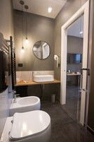 A modern bathroom with a sink, mirror, and toilet.