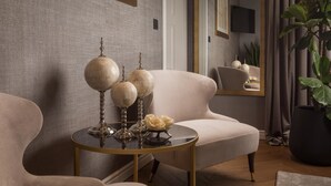 A modern living room with a sofa, a round coffee table, and decorative items. - Five Elements Luxury Rooms (Split)