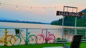 A lakeside view with a sign reading "Lake House" and bicycles parked along the railing. - The Lake House (Pokhara)