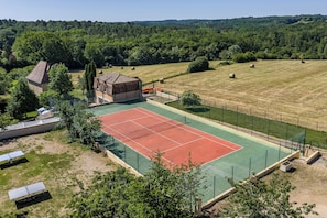 An outdoor tennis court with a green and red surface, surrounded by a fence and trees. - Gite La Tour - Cocoon for 2 with pool and nature (Saint-Geyrac)