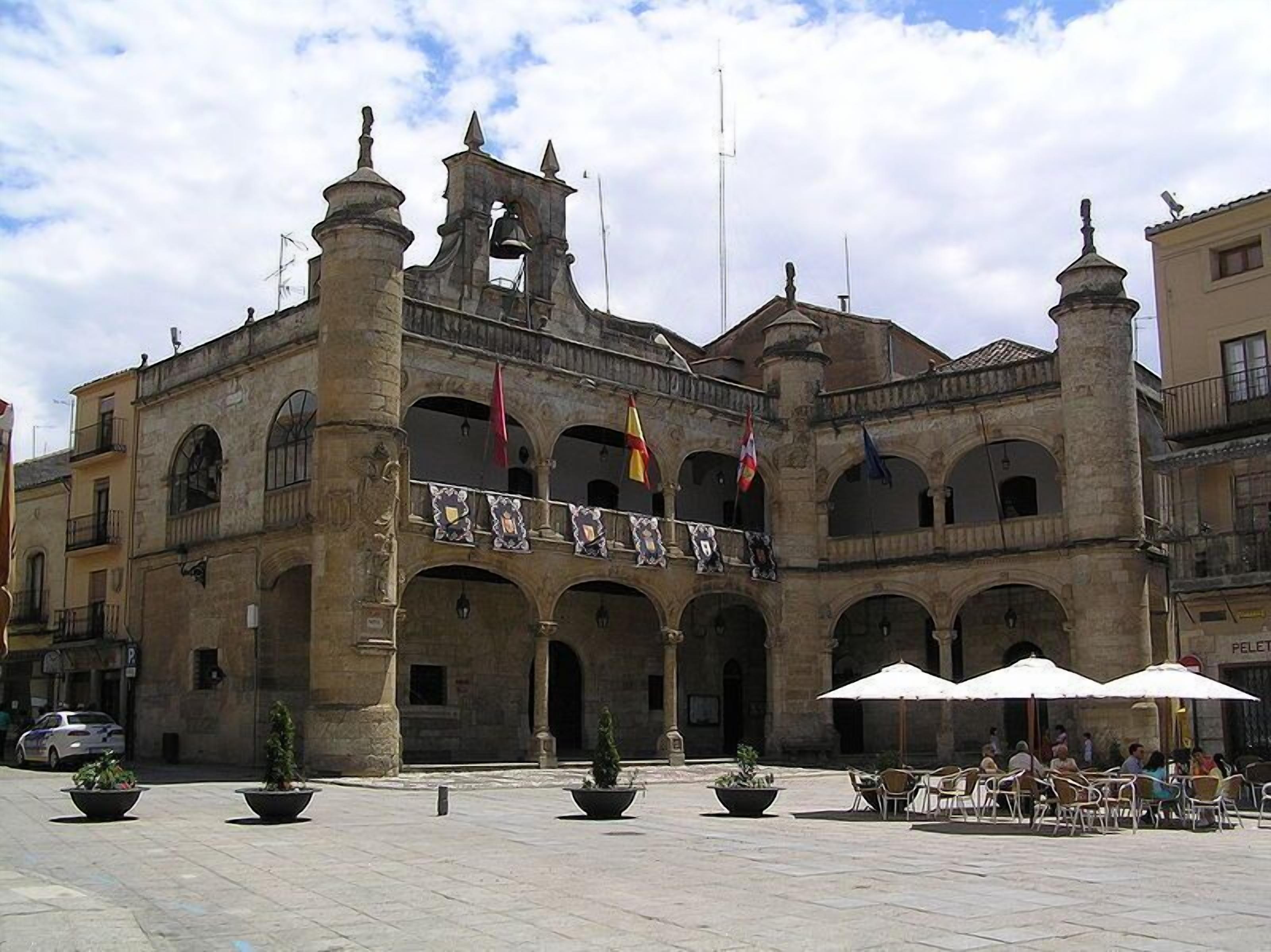 Edifici històric amb un pati central, amb una torre de campanars i múltiples arcs.