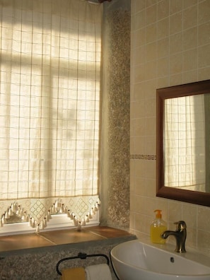 A bathroom with a large window, a sink with a mirror, and a towel rack. - El Condado Casa Rural (Fuentes de Onoro)