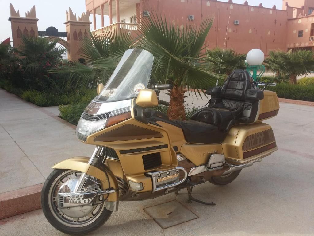 Una motocicleta estacionada frente a un edificio de estilo arquitectónico distintivo.
