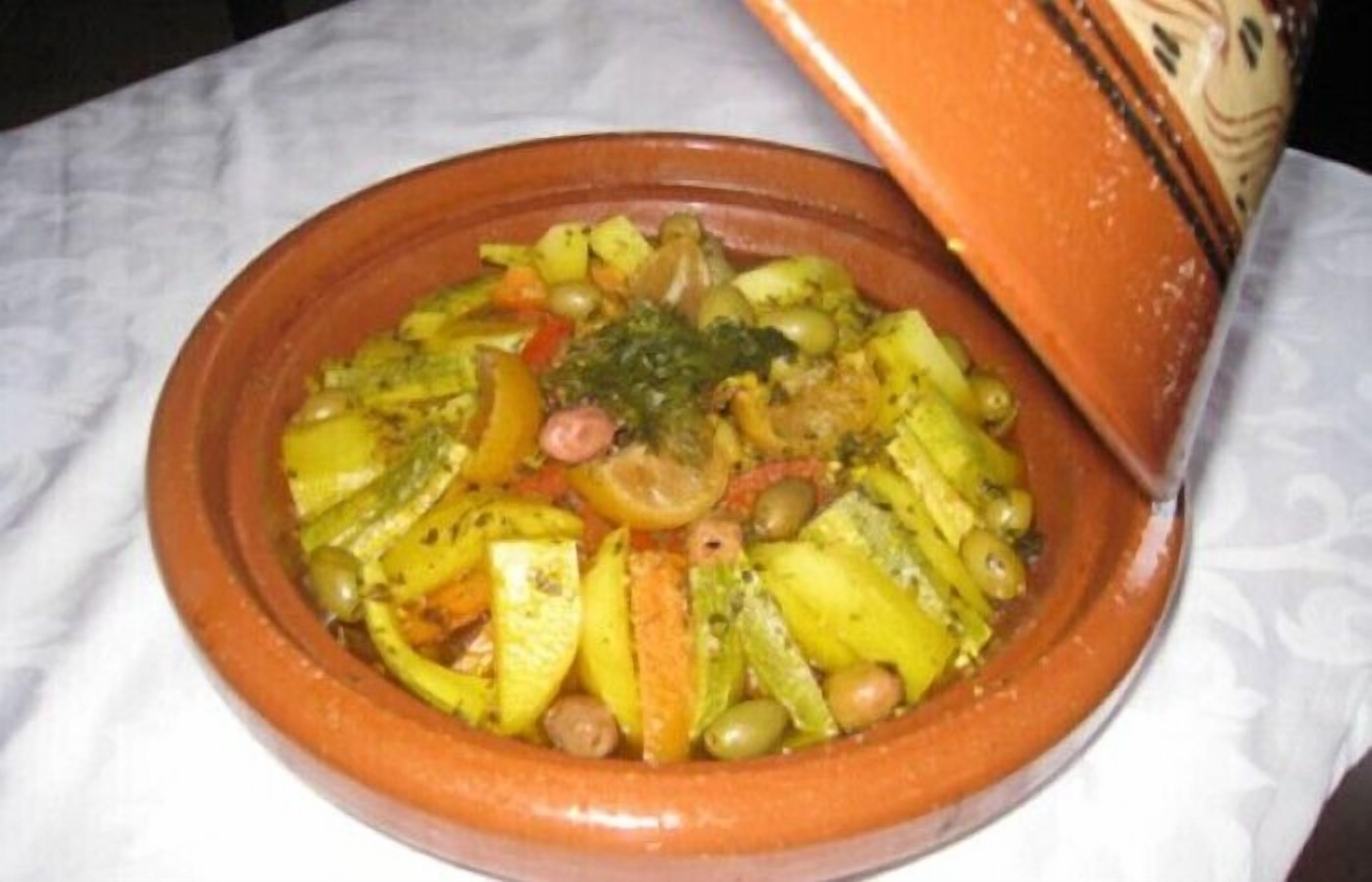 Ein traditioneller Tonkrug, gefüllt mit Gemüsesuppe, auf einer weißen Tischdecke.