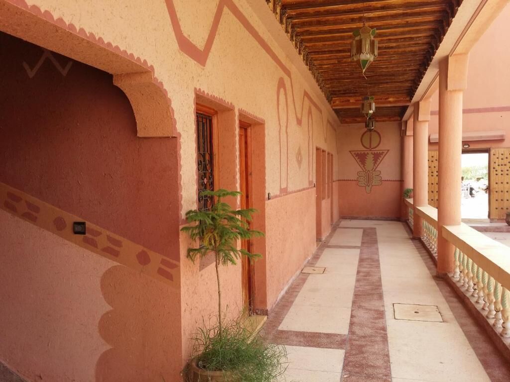 Un pasillo con suelo de baldosas, una planta en maceta y un techo decorativo.