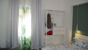 Ein Schlafzimmer mit einem Bett, einem Kleiderschrank und einem Schreibtisch.