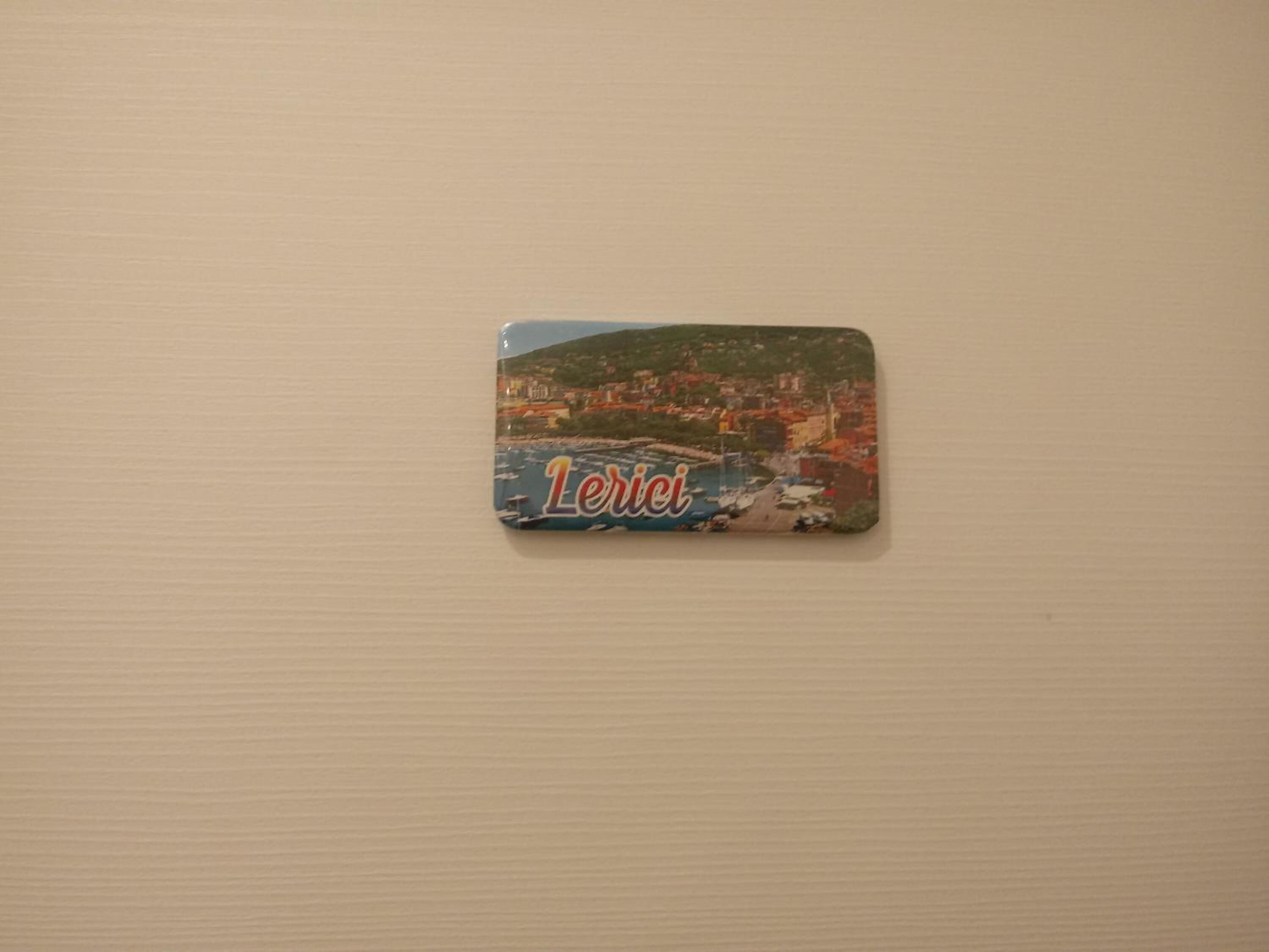 A small, rectangular object with a cityscape and the word "Lerici" on it.