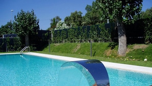 Une piscine dotée d’une terrasse en bois et d’une structure métallique.