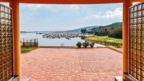 A covered terrace with a view of a marina and hills. - Apartment Andrea L (Medulin)