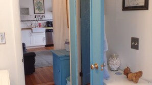 A room with a blue door, a white sink, and a small rug. - 2 Bedroom Private Apt. in 1825 Whaler's Home on Duck Creek (Wellfleet)