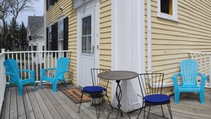 A deck with blue chairs and a small table, surrounded by a white railing. - 2 Bedroom Private Apt. in 1825 Whaler's Home on Duck Creek (Wellfleet)