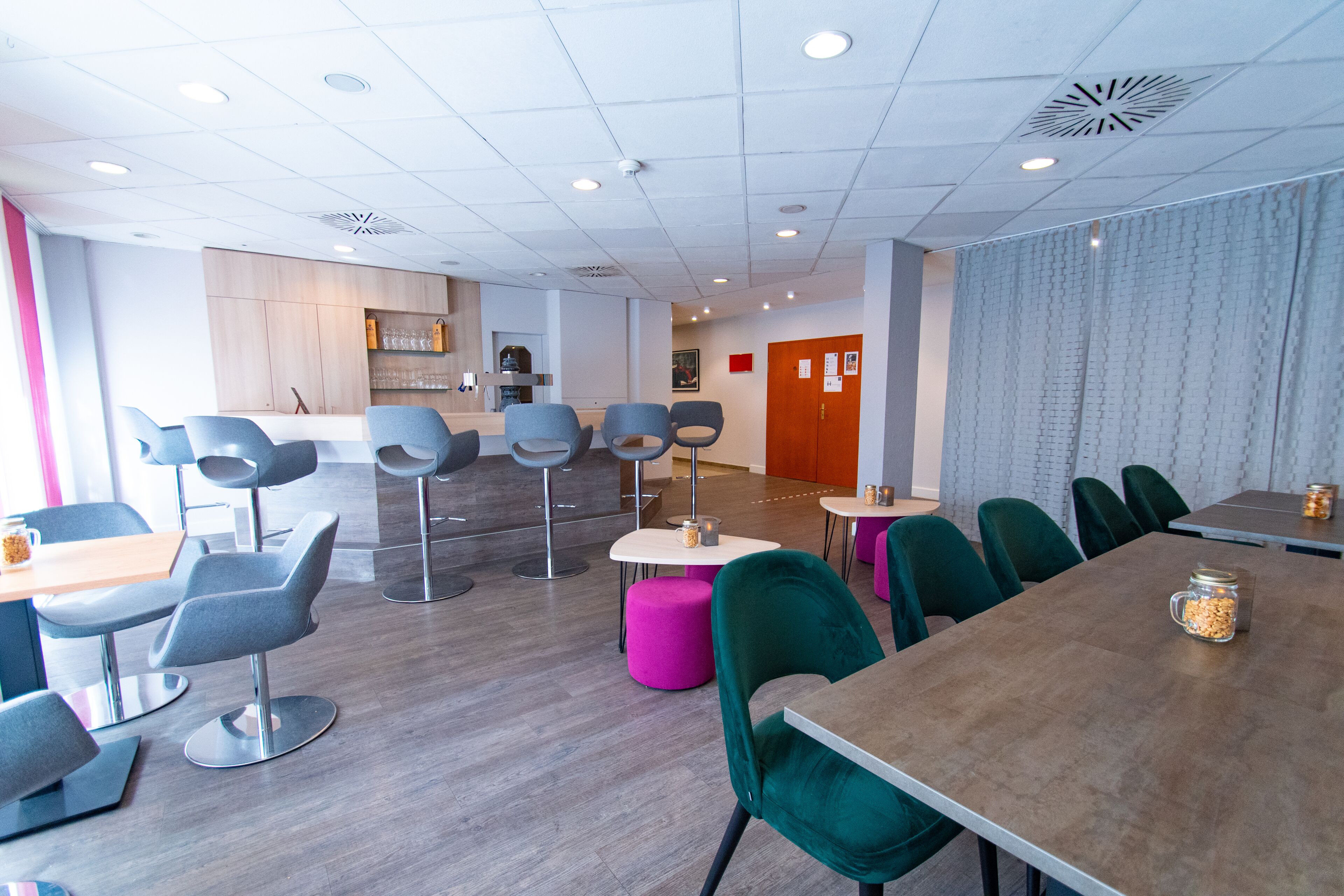 Een moderne eetruimte met hoge tafels en stoelen, een bar en een houten toonbank.