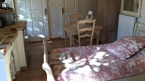 Ein Schlafzimmer mit Bett, Stuhl, Schreibtisch und Kleiderschrank.