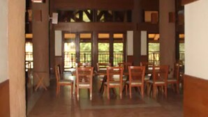 A spacious room with wooden beams, a chandelier, and a dining area with tables and chairs. - Miguel's Place at Canyon Woods Resort (Laurel)