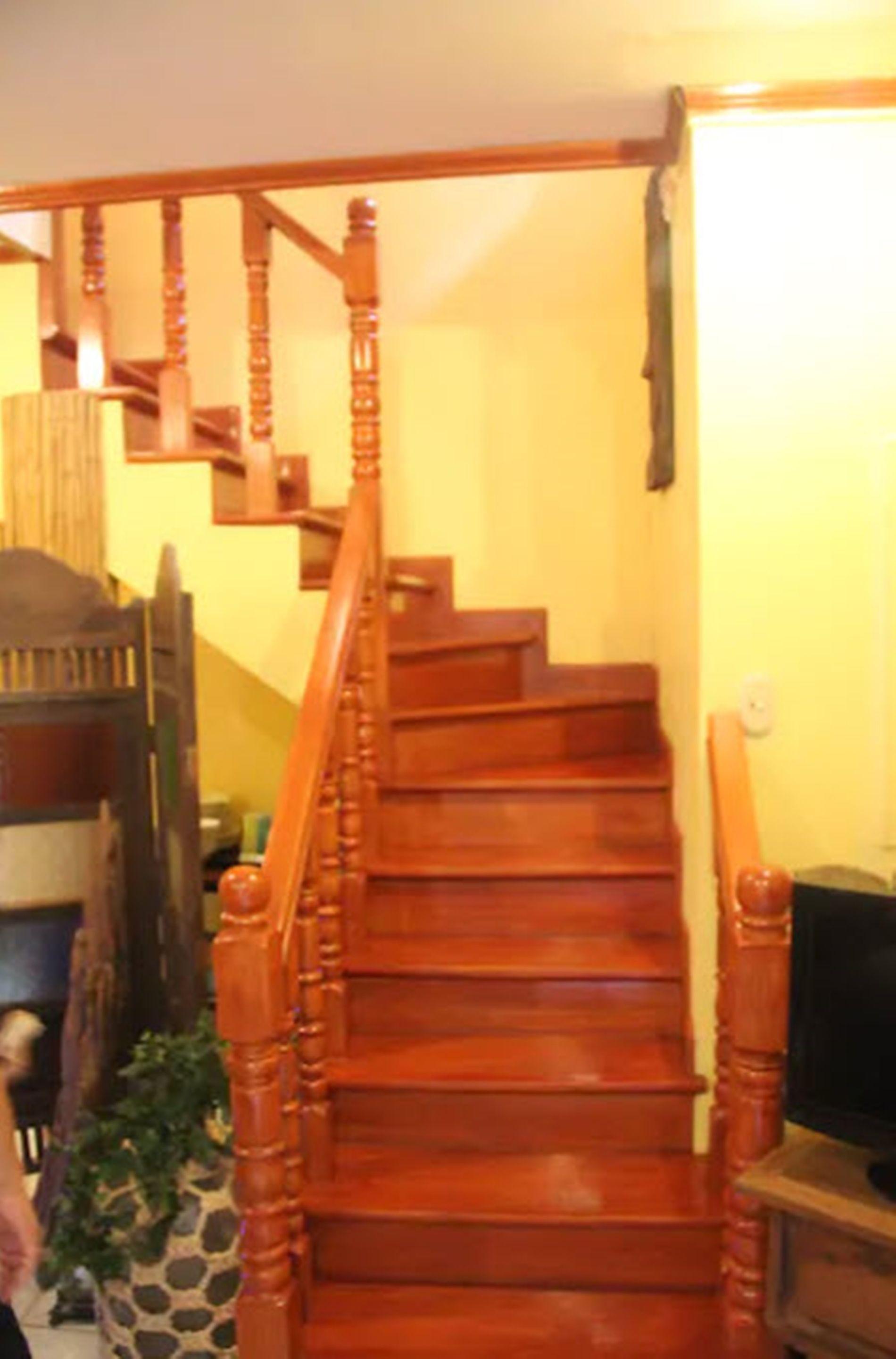 A wooden staircase with a handrail, leading to an upper floor.