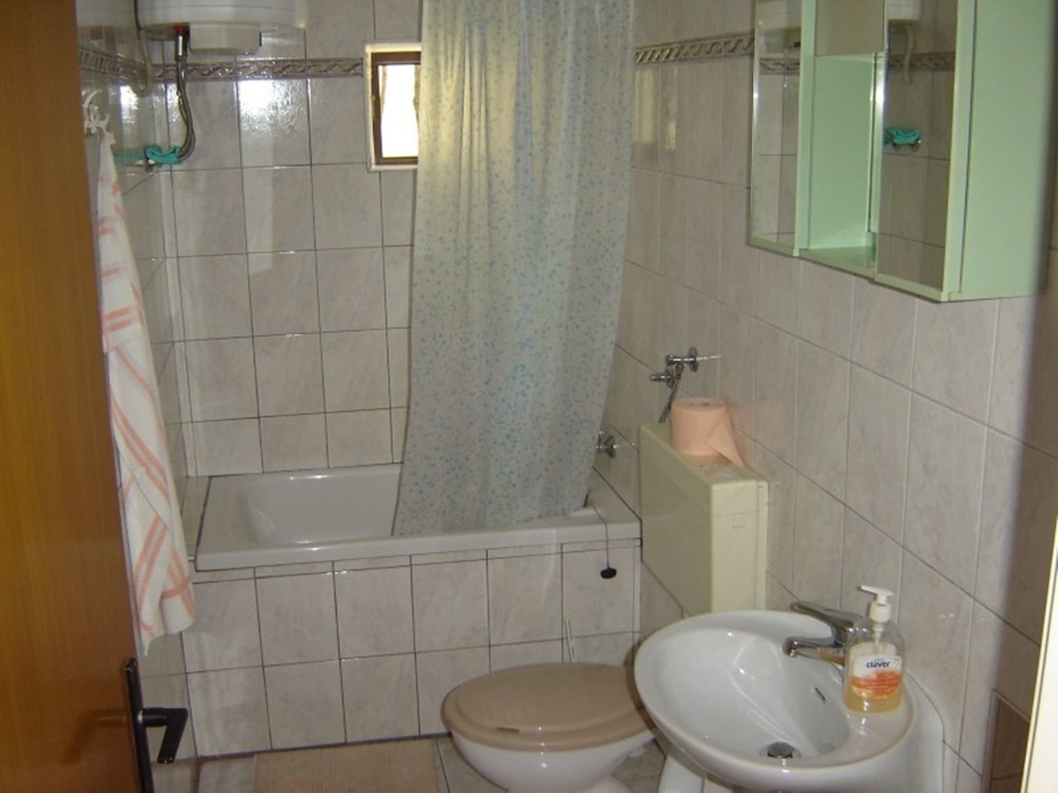 A bathroom with a toilet, sink, and bathtub.