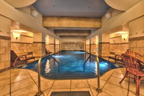Un'ampia piscina interna con acqua cristallina, circondata da pareti e panche piastrellate.