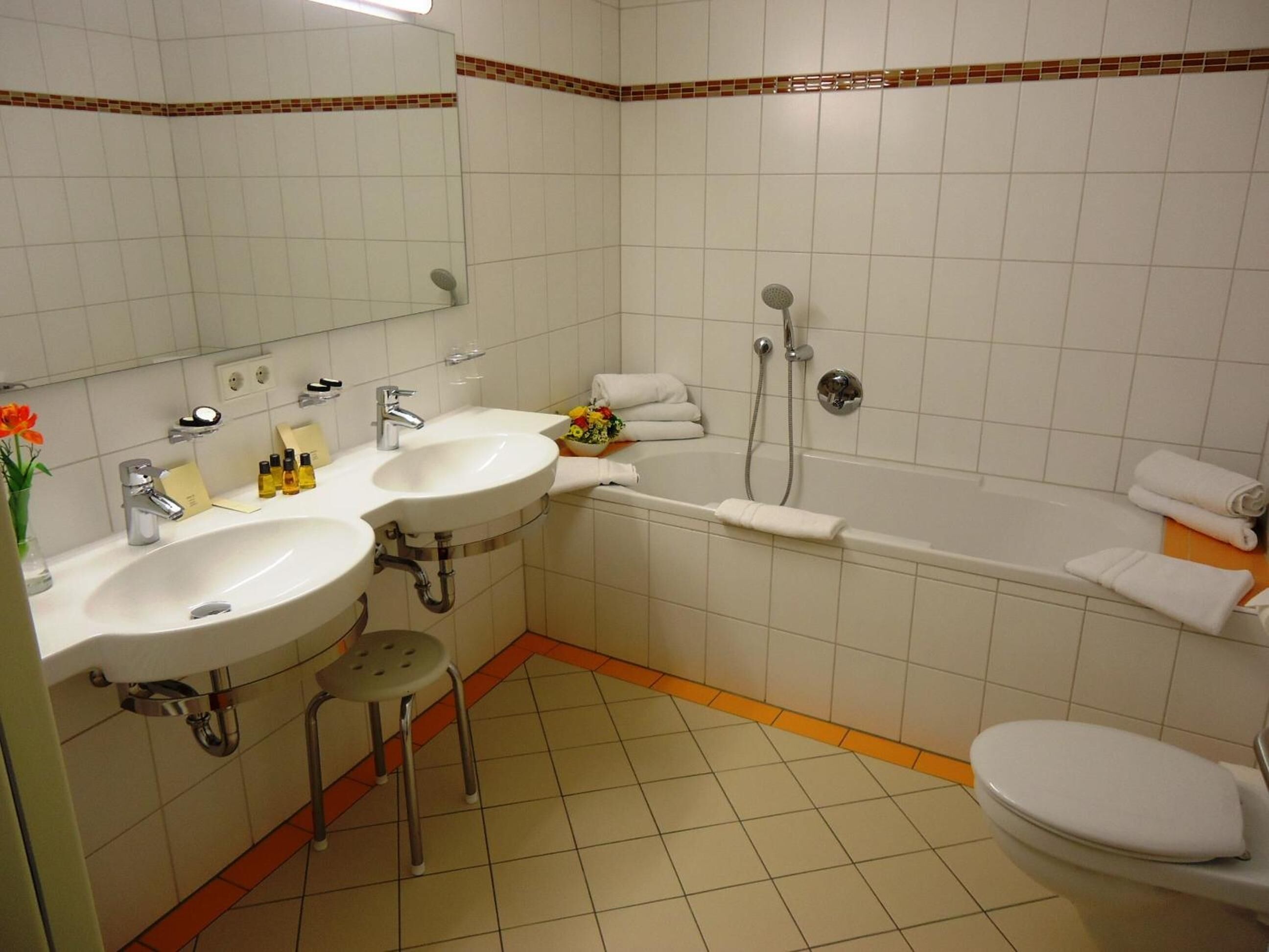 A bathroom with two sinks, a bathtub, and a toilet.