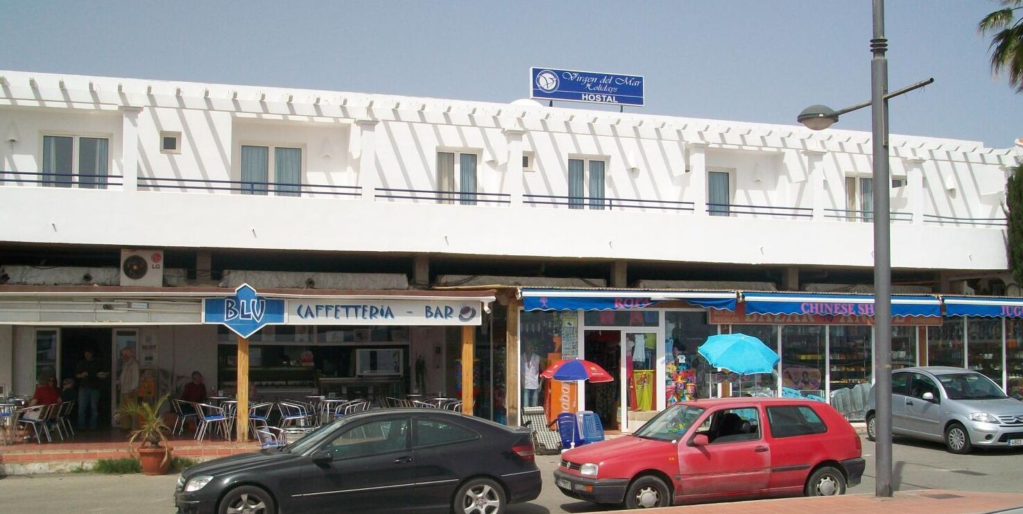 A building with a sign for a hostel and a bar.