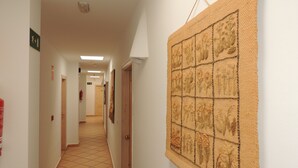 Ein Flur mit Fliesenboden, einem Feuerlöscher und einem an der Wand befestigten Schwarzwert.