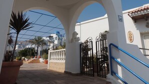 Ein Hotel mit weißer Fassade, blauer Geländer und einem Tor.