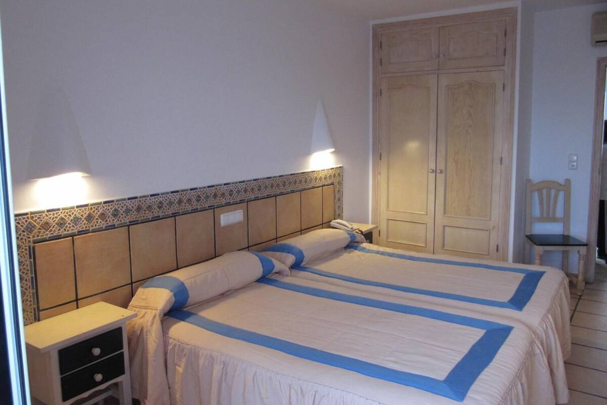 Ein Schlafzimmer mit Bett, Nachttisch, Schrank und Stuhl.