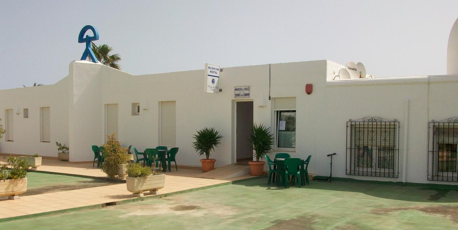 A building with a reception desk, outdoor seating area, and a satellite dish.