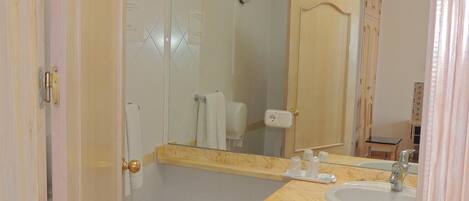 Un baño con tocador de mármol, lavabo, espejo y bidé.