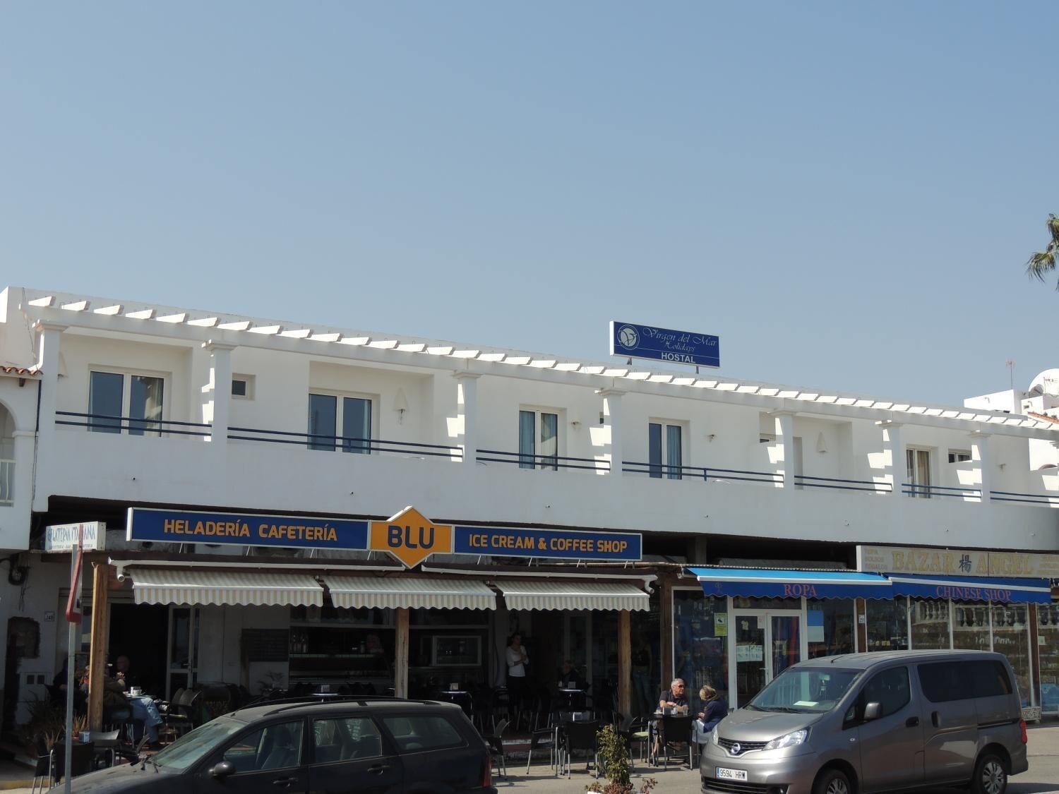 Un edificio con un letrero que indica 'Viver del Mar Hostal' y una tienda llamada 'Bazar'.