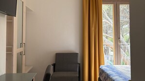 A room with a bed, a desk, a chair, and a television. - Hotel Villa Mare (Posada)
