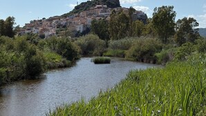 A town on a hill with a river in the foreground and a tower on top. - Hotel Villa Mare (Posada)