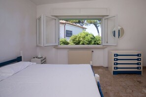 A bedroom with a bed, a dresser, a mirror, and a window with an open shutter. - N130 - Numana, two-room apartment with sea view at 200mt from the beach (Numana)