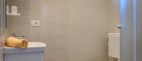 Une salle de bain avec des toilettes, un lavabo et une petite fenêtre.