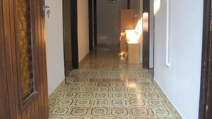 A hallway with patterned flooring, wooden doors, and a light fixture in the distance. - Apartment Razum A5 (Pula)