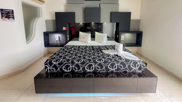 Een moderne hotelkamer met een groot bed, een flatscreen televisie, een minibar en een ingebouwde kachel.