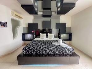 Ein modernes Hotelzimmer mit einem großen Bett, einem Flachbildfernseher, einer Minibar und einer fest installierten Heizung.