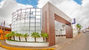 Een modern hotel met een opvallende glazen gevel en een grote overstek.