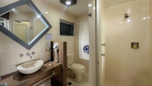 Een moderne badkamer met een grote spiegel, een wastafel, een toilet en een douche.