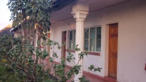A building with a white exterior, large windows, and a wooden door. - Nalumba 2 Lodge (Mongu)