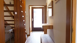 A hallway with wooden flooring, a bench, a wooden partition, and a door leading to another room. - FeWo Walter - House 2 St.- Andreasberg, south-facing slope, quiet, family-friendly, WLAN (St. Andreasberg)