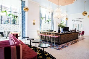 A modern hotel lobby with a bar area, seating arrangements, and decorative elements.